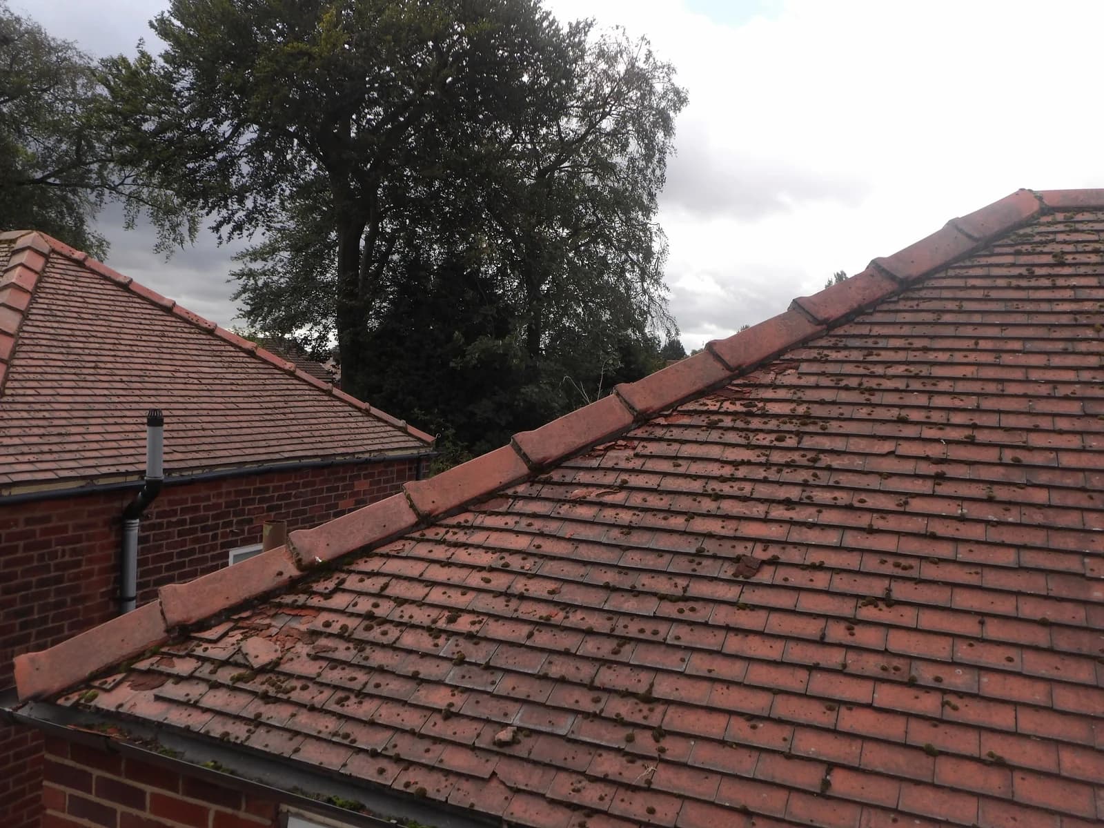 Broken tiles and displaced fragments on a clay tiled roof.